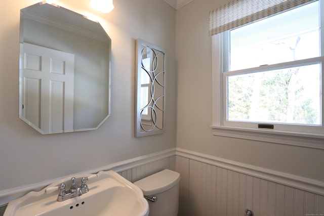 bathroom with a wainscoted wall, a sink, and toilet