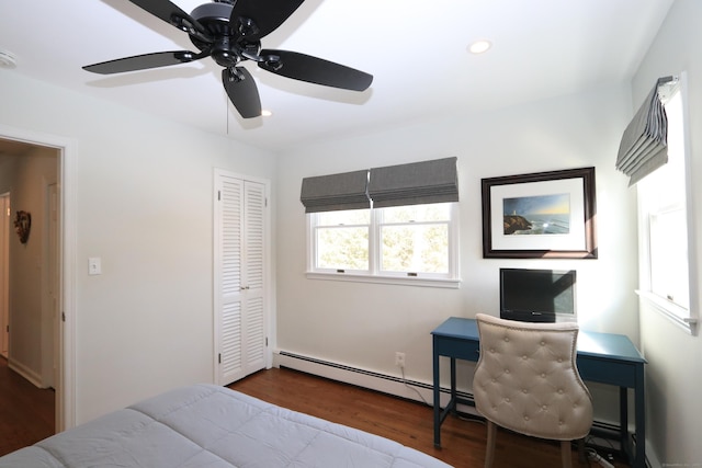 bedroom featuring a ceiling fan, wood finished floors, a baseboard heating unit, a closet, and recessed lighting