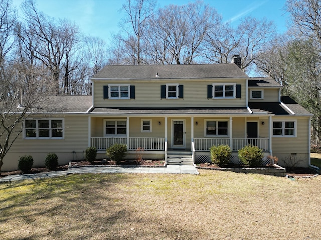 view of front of home with a front lawn, a chimney, covered porch, and crawl space