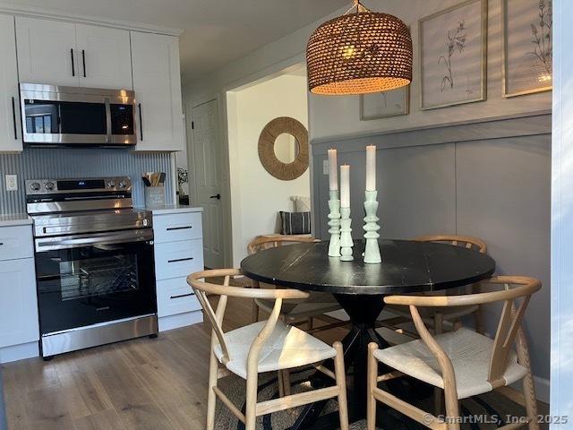 dining space with dark wood-style flooring