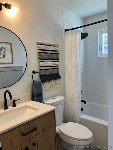 full bathroom featuring shower / tub combo, vanity, and toilet