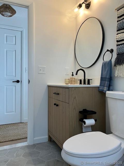 half bathroom with toilet and vanity