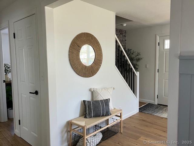 entrance foyer featuring stairway, wood finished floors, and baseboards