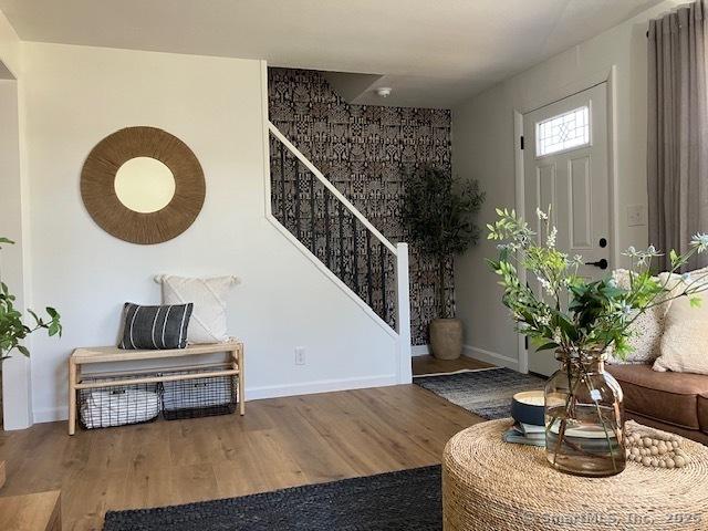 entryway featuring stairway, baseboards, and wood finished floors