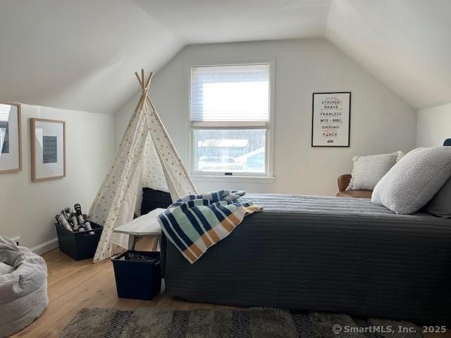 bedroom featuring vaulted ceiling, wood finished floors, and baseboards