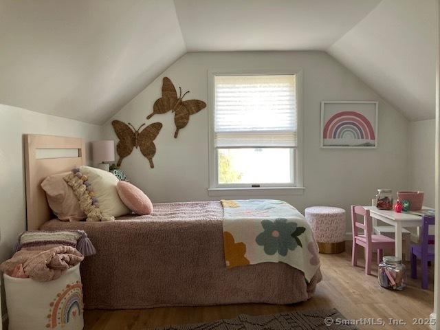 bedroom with lofted ceiling and wood finished floors