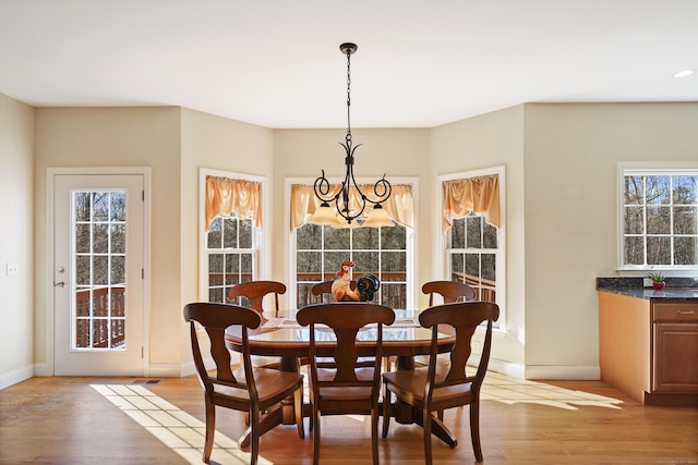 dining room with light wood-style floors, plenty of natural light, and baseboards