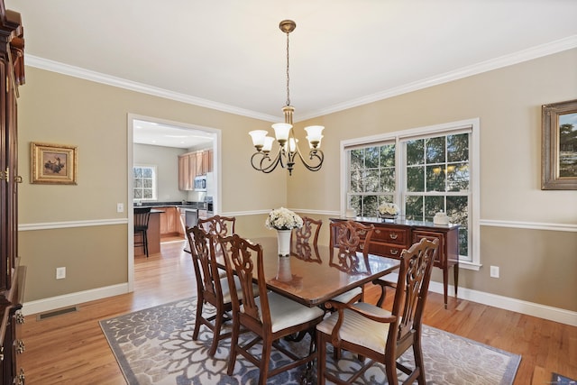 dining room featuring baseboards, visible vents, light wood finished floors, and an inviting chandelier