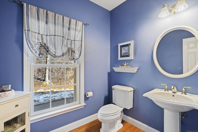 bathroom featuring toilet, baseboards, and wood finished floors