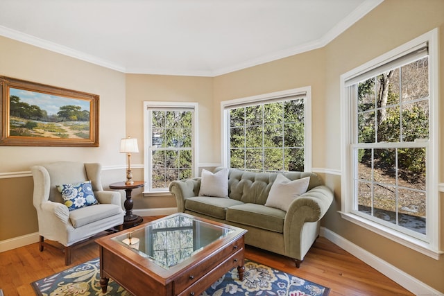 living area with crown molding, wood finished floors, and baseboards