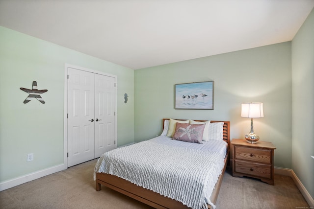 carpeted bedroom with baseboards and a closet