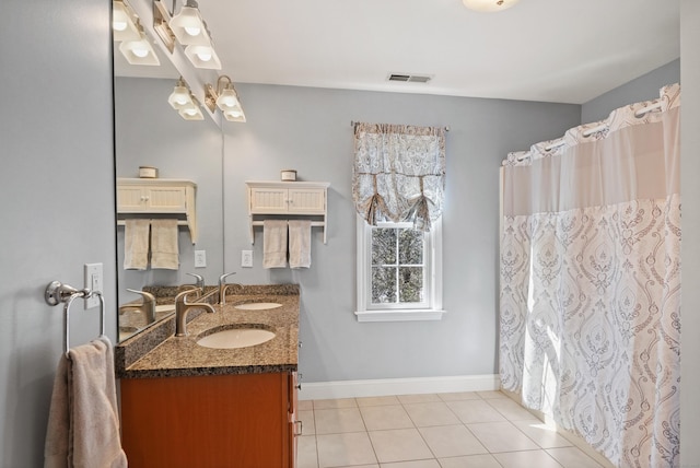 bathroom featuring tile patterned flooring, visible vents, a sink, and baseboards