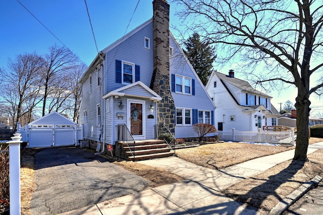 view of front of home featuring a garage, a gate, fence, and a chimney