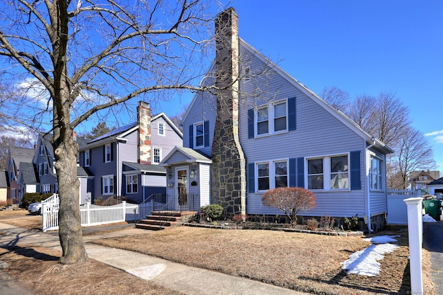 view of front of house featuring fence and a chimney