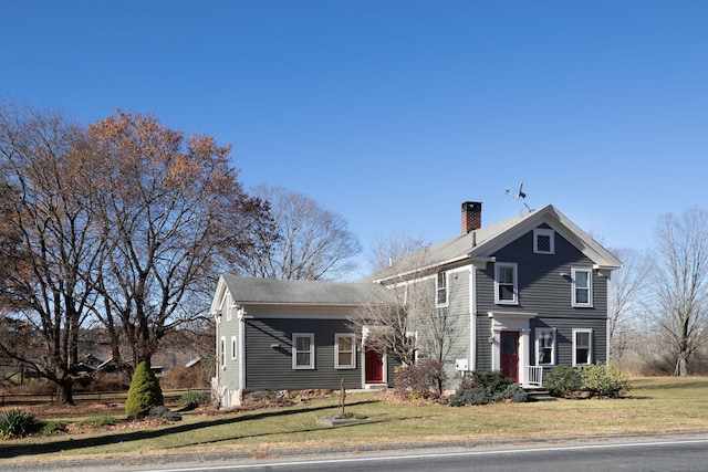 view of front facade with a front lawn and a chimney