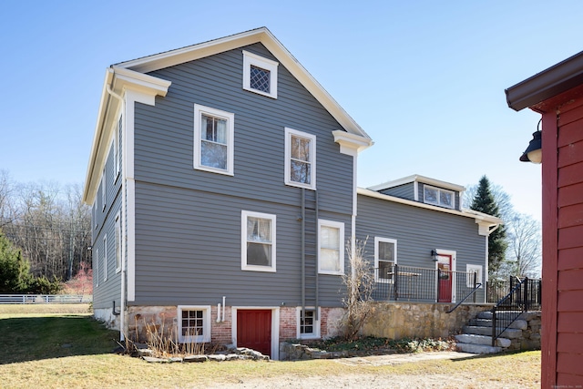 rear view of property with a lawn and fence