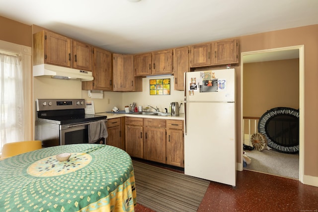 kitchen with brown cabinets, freestanding refrigerator, light countertops, stainless steel range with electric cooktop, and under cabinet range hood