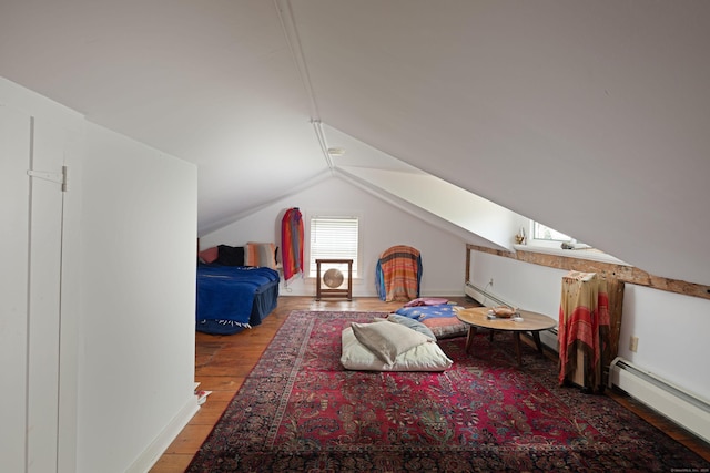 bedroom featuring lofted ceiling, baseboard heating, and wood finished floors