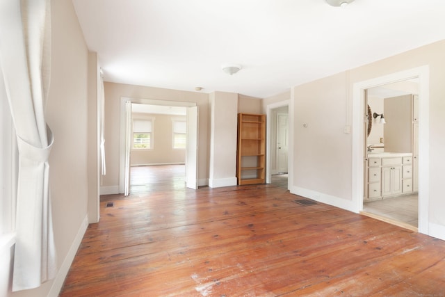 spare room featuring baseboards, visible vents, and light wood finished floors