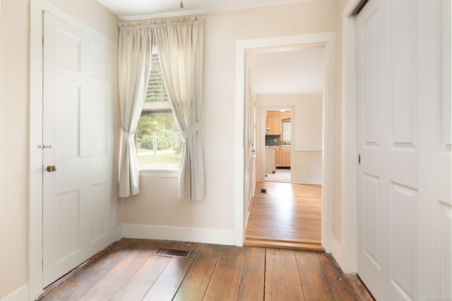 interior space featuring baseboards, visible vents, and dark wood finished floors