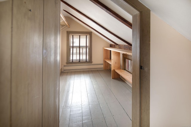 additional living space featuring vaulted ceiling, a baseboard heating unit, and light wood-style flooring