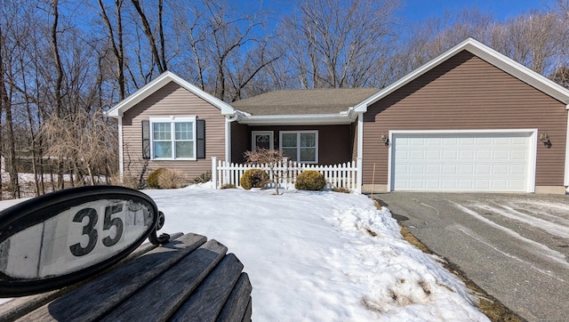 ranch-style home with a garage and aphalt driveway