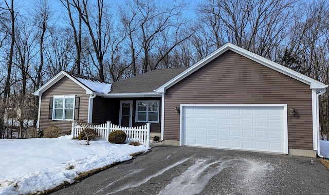 ranch-style home with driveway, an attached garage, and fence