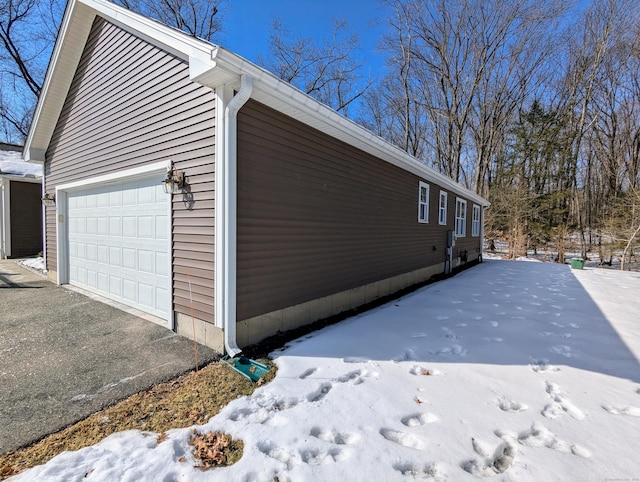 view of snow covered exterior with a detached garage