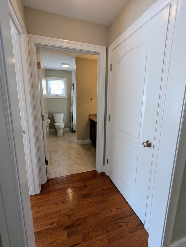 hall featuring baseboards and wood finished floors