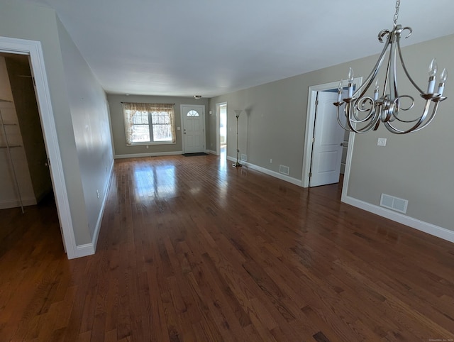 unfurnished living room with dark wood finished floors, visible vents, and baseboards