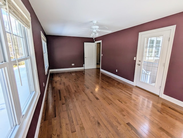 empty room featuring ceiling fan, hardwood / wood-style floors, and baseboards