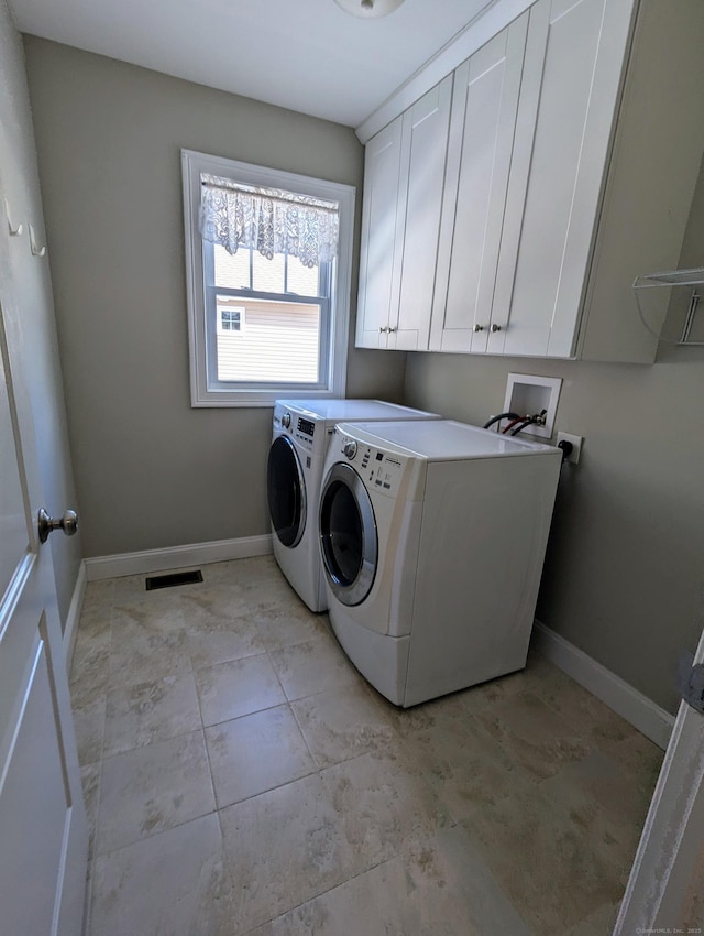 washroom with independent washer and dryer, cabinet space, visible vents, and baseboards