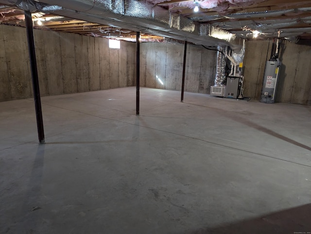 unfinished basement featuring gas water heater