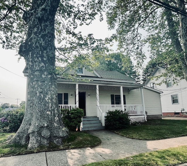 view of front of property with covered porch and a front lawn