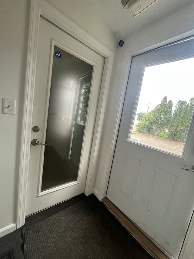 doorway featuring dark carpet