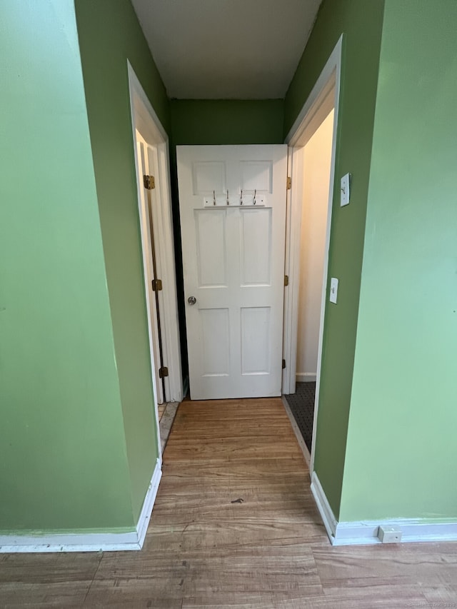 hallway featuring light wood-style floors and baseboards