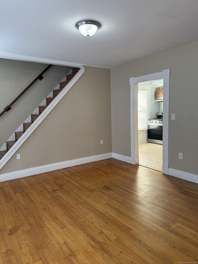 interior space featuring stairway, wood-type flooring, and baseboards