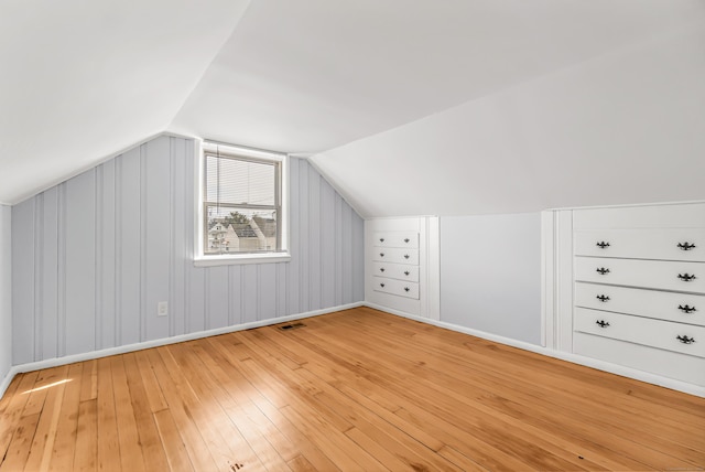 bonus room with lofted ceiling, visible vents, and light wood-style flooring