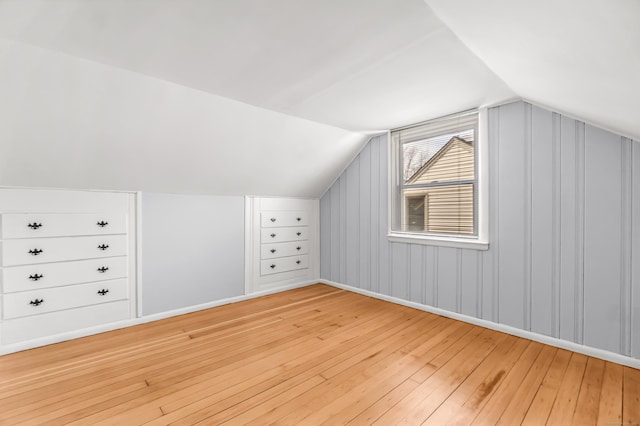 bonus room with lofted ceiling and light wood-style flooring