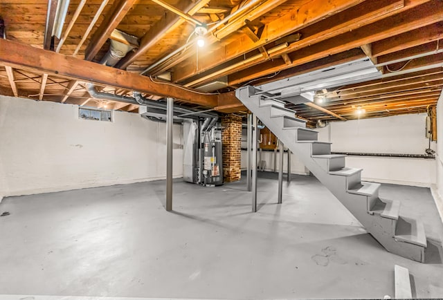 unfinished basement featuring water heater and stairway