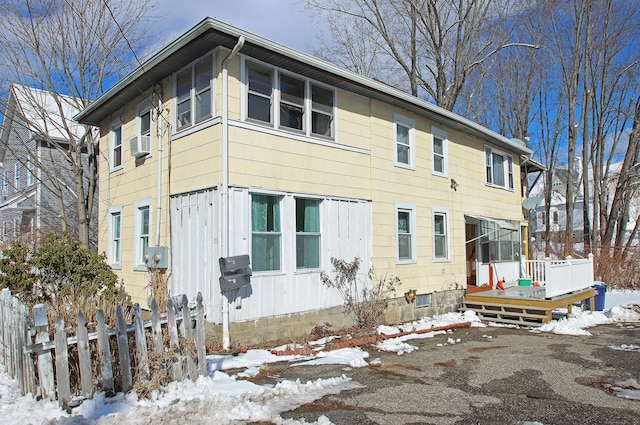 exterior space with fence, a deck, and cooling unit