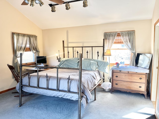 carpeted bedroom with lofted ceiling and baseboards