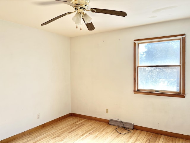 spare room with baseboards, a ceiling fan, and light wood-style floors