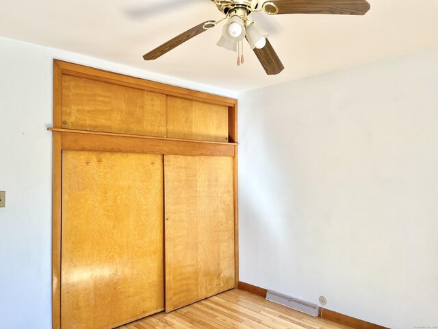 unfurnished bedroom featuring light wood finished floors, baseboards, visible vents, a ceiling fan, and a closet