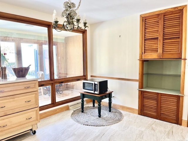 office area with a notable chandelier and baseboards