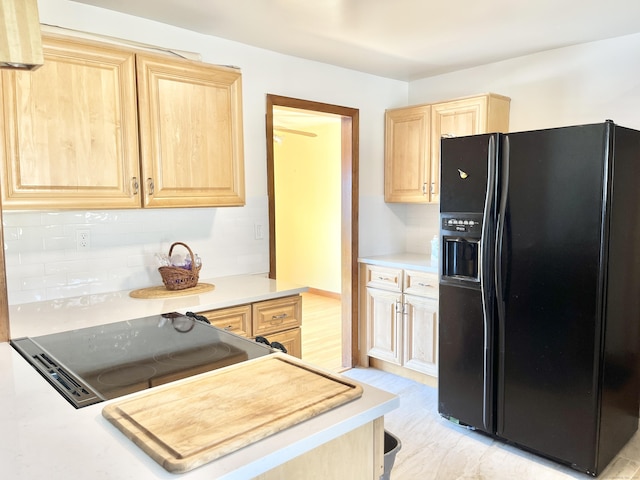 kitchen with light brown cabinets, light countertops, and black fridge with ice dispenser