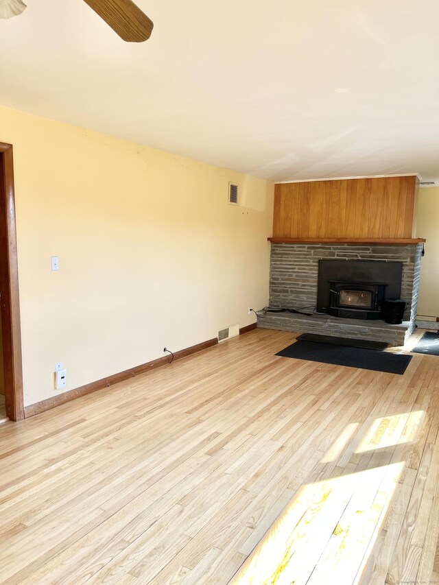 unfurnished living room featuring light wood finished floors, baseboards, visible vents, and ceiling fan