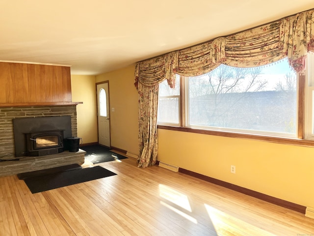 unfurnished living room featuring a fireplace, light wood-style flooring, and baseboards