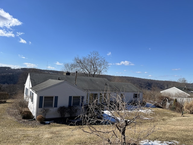 rear view of house with a shingled roof