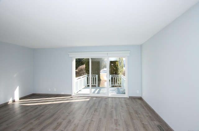 spare room with light wood-type flooring, baseboards, and visible vents